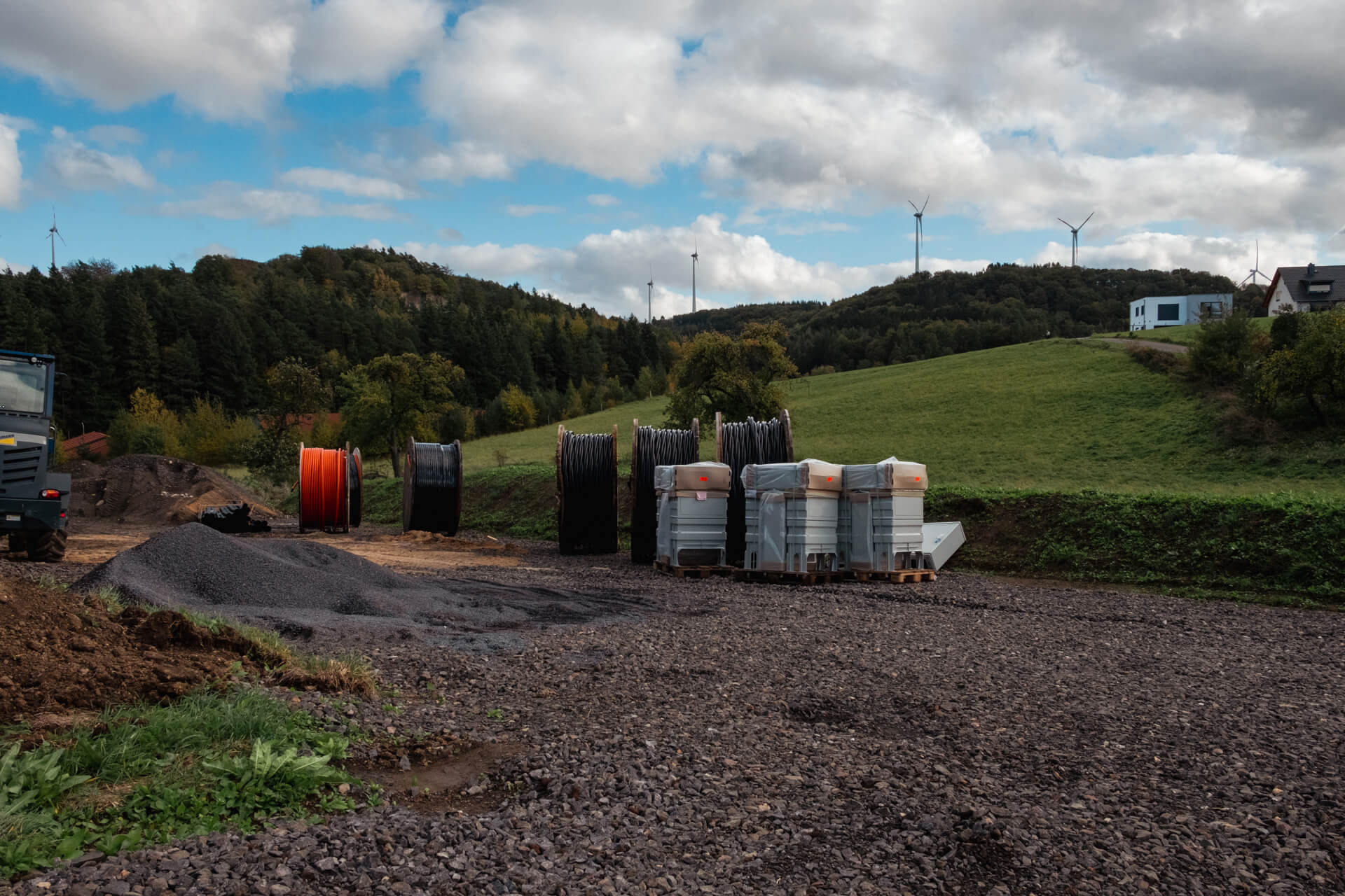 Zwischenlager mit verschiedenen Baumaterialien, neuen Verteilerkästen und Glasfaserkabeln.